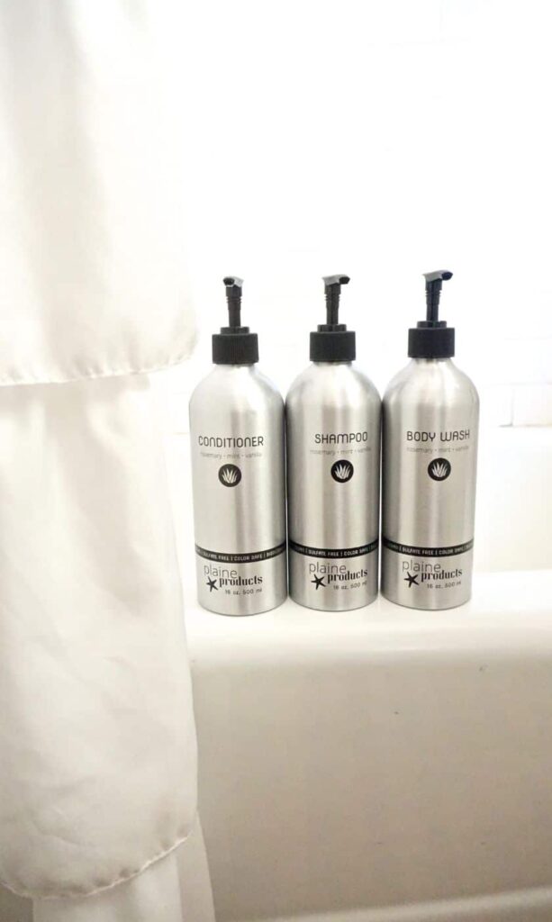 sustainable shampoo, conditioner, and body wash on the ledge of a tub
