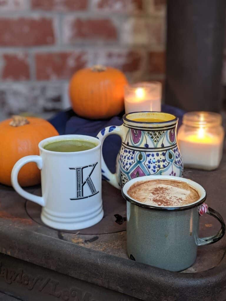 close-up image of three mugs filled with cozy beverages