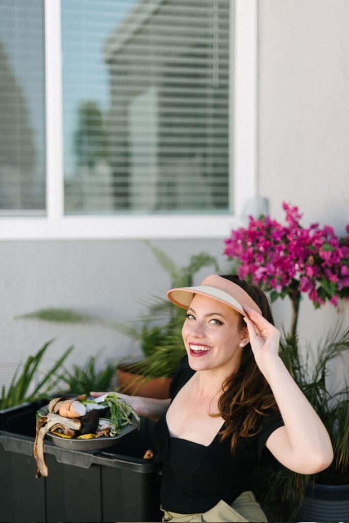woman holding scrap foods ready to add to compost diy bin