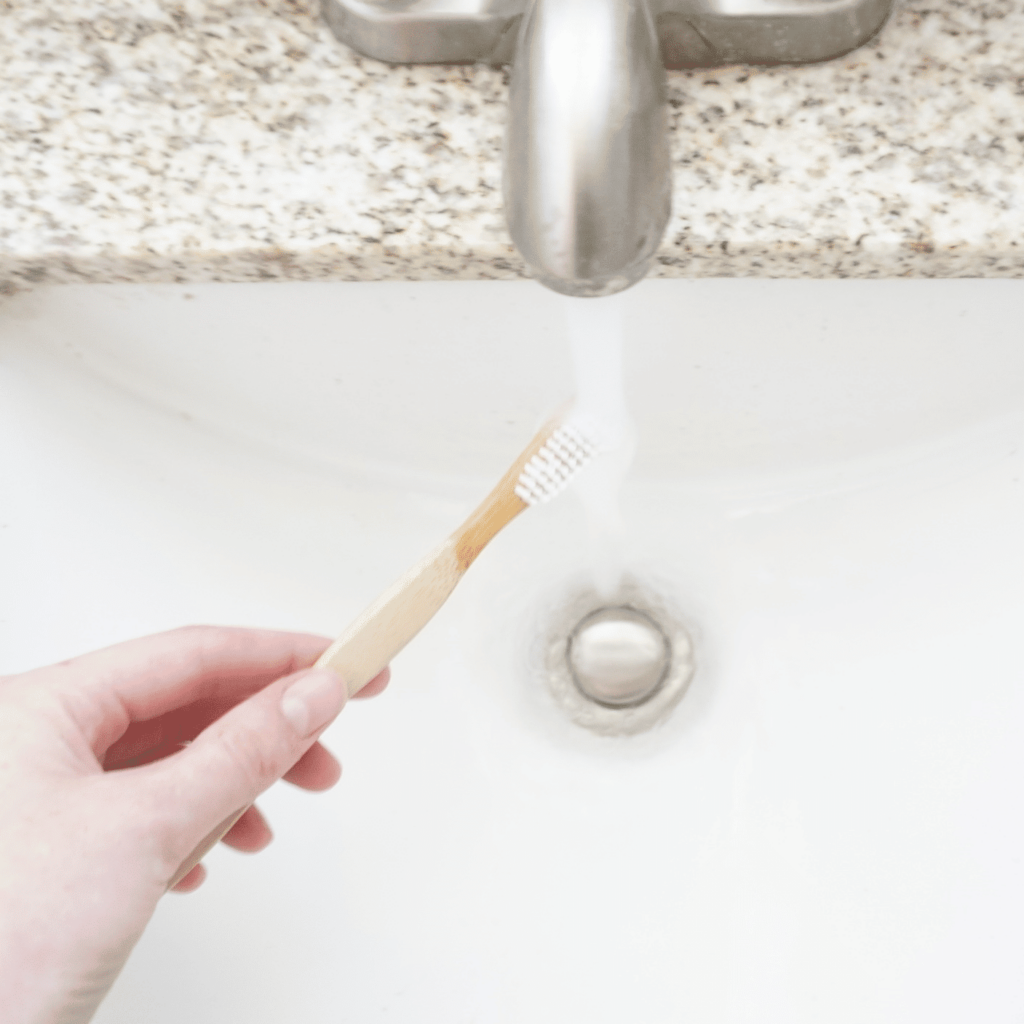 A brush with bamboo held under running water