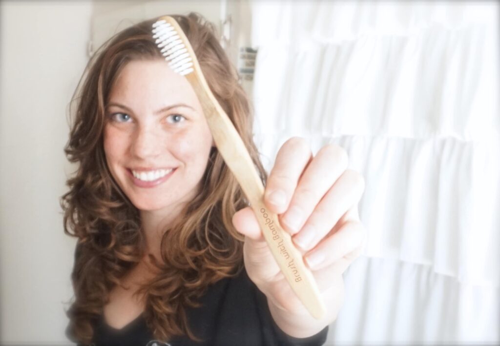 woman holding a bamboo toothbrush