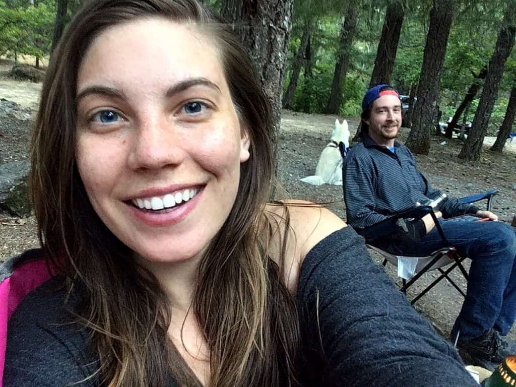 A woman and man sitting in camp chairs during an eco friendly camping trip. 