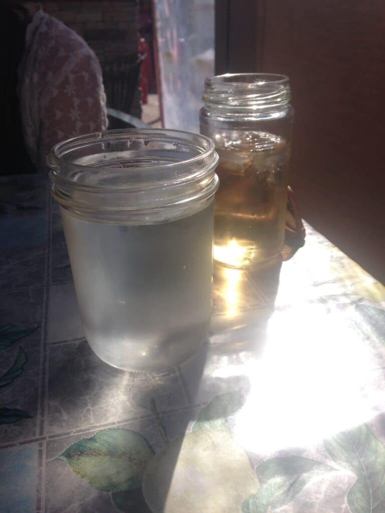 Two mason jars as drinking glasses filled with ice water 