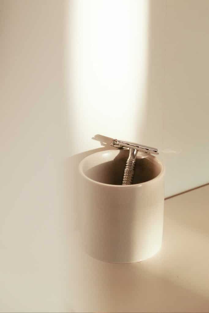 A razor in a ceramic cup to illustrate websites like Amazon for self care products.